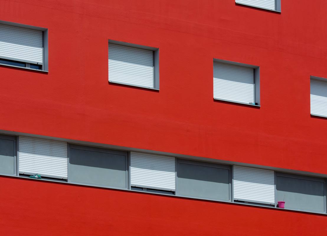 Volets roulants blancs sur façade rouge
